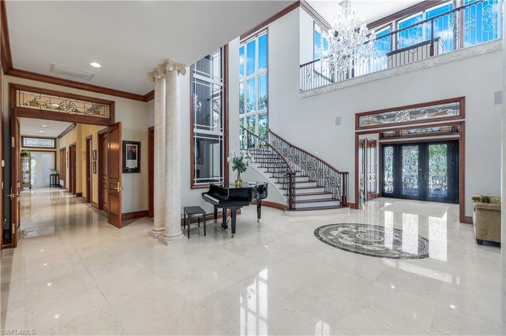 Common area with crown molding, recessed lighting, and a towering ceiling