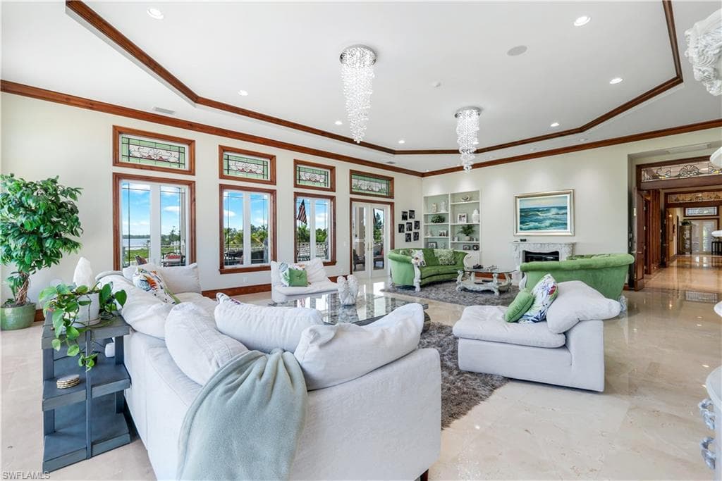 Living area featuring crown molding, recessed lighting, and a chandelier