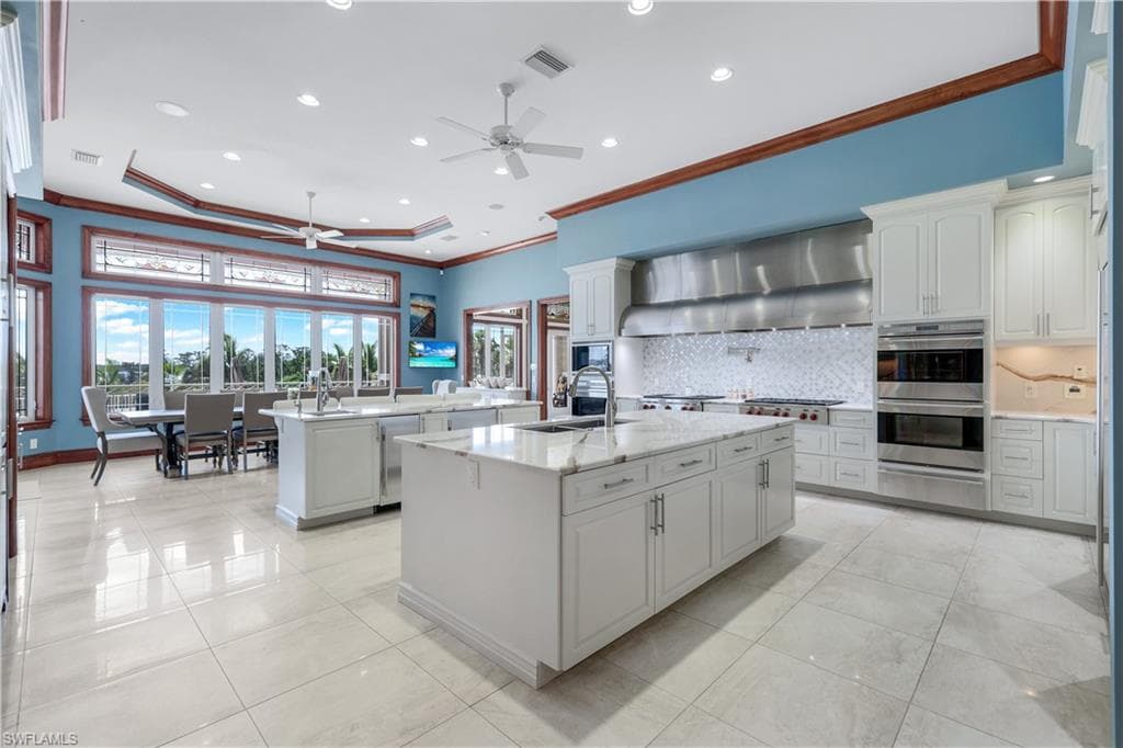 Kitchen with crown molding, ceiling fan, tasteful backsplash, recessed lighting, and appliances with stainless steel finishes