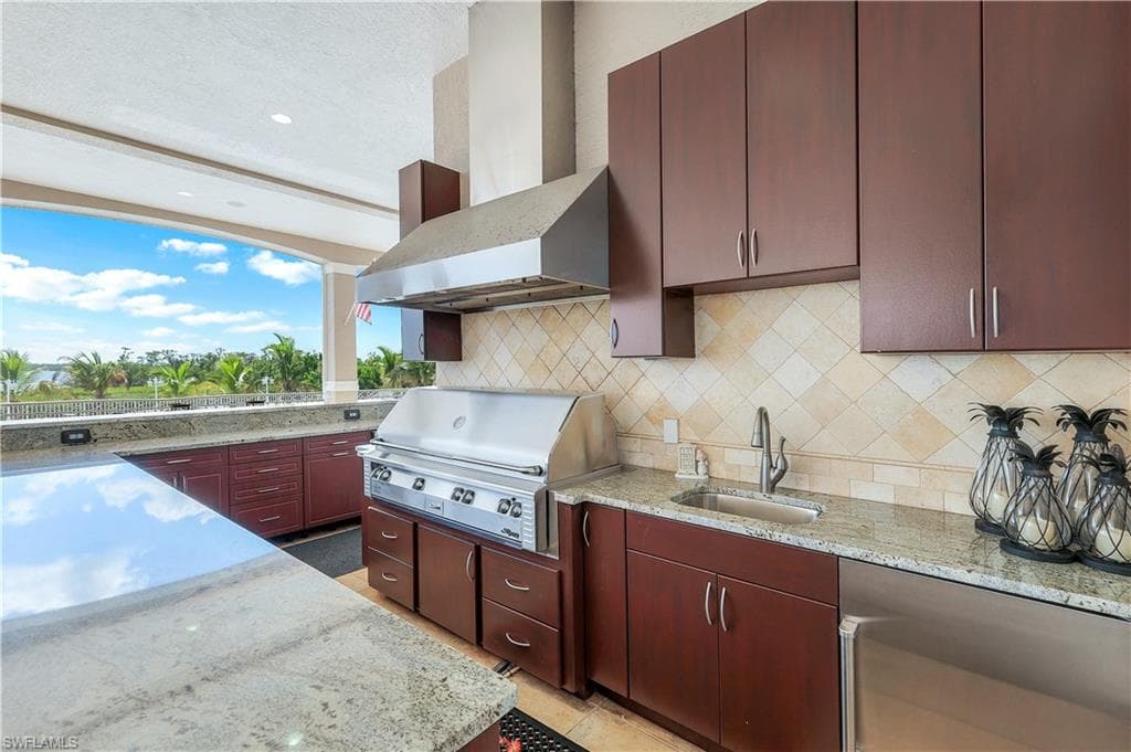 View of patio / terrace with exterior kitchen featuring a natural gas grill and plenty of cabinetry