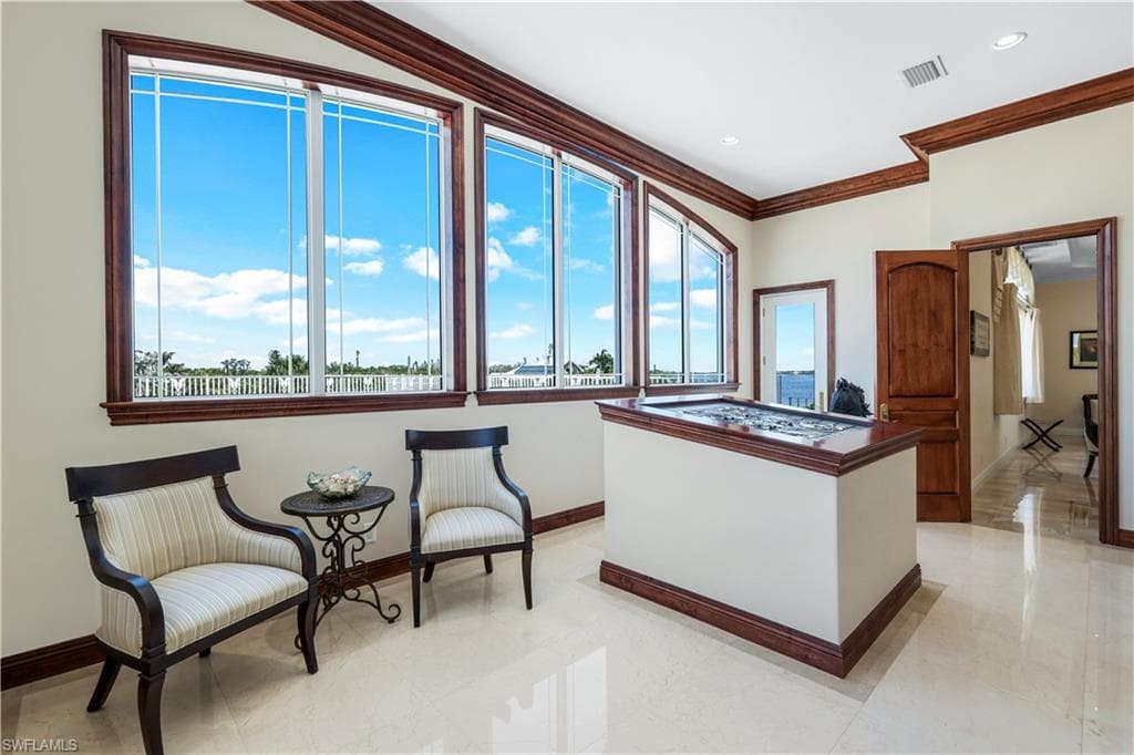 Living area with baseboards and crown molding and entry to carport rooftop