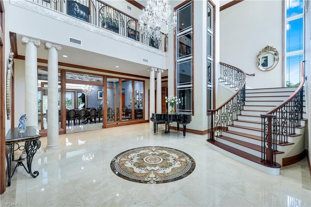 Lobby featuring a towering ceiling, ornamental molding, and stairway