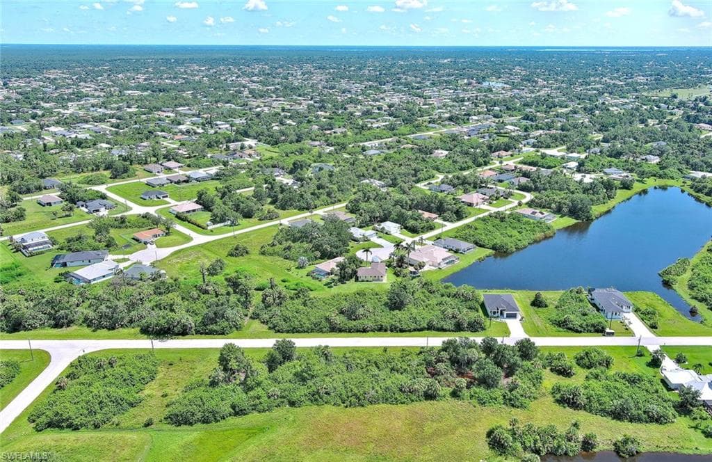 Aerial view of property's location featuring a large body of water and nearby suburban area