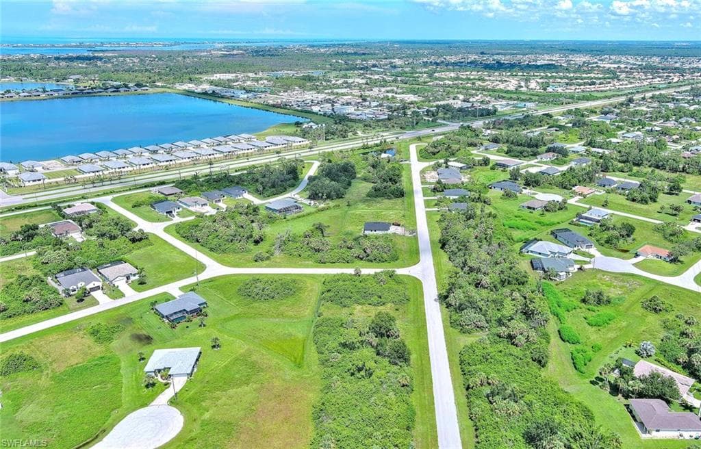 Aerial view of property's location with a large body of water and nearby suburban area