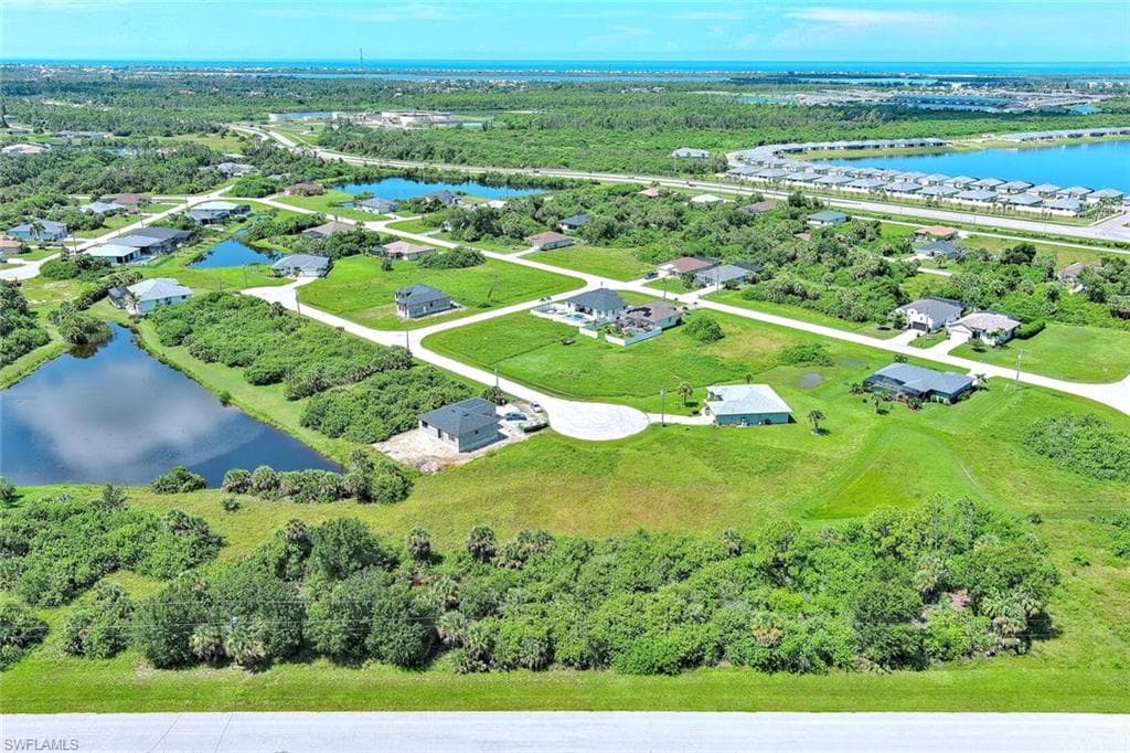 Aerial perspective of suburban area featuring a nearby body of water