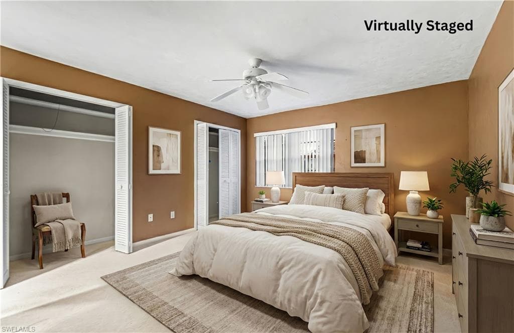 Bedroom with multiple closets, carpet, and a ceiling fan