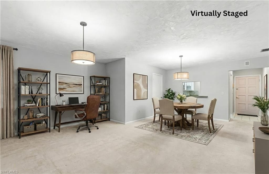 Dining room featuring light colored carpet, a desk, and a textured ceiling