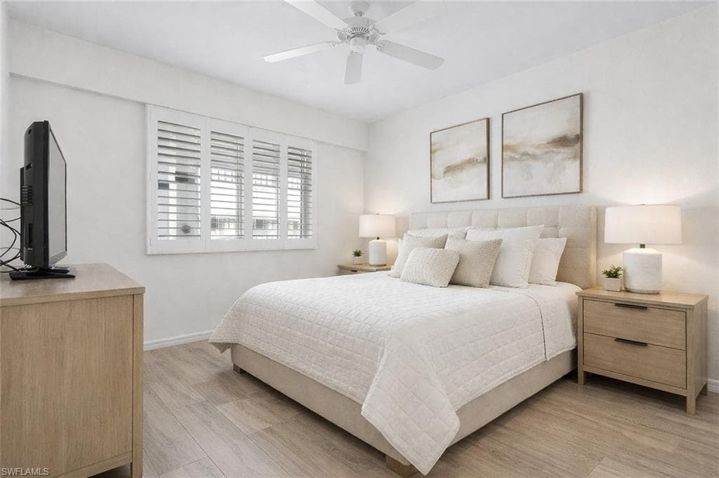 Virtual staged bedroom featuring light wood-style flooring and ceiling fan