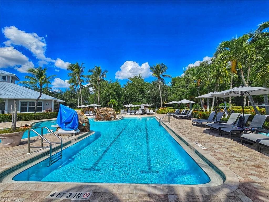 Community pool featuring a patio area and area for grilling