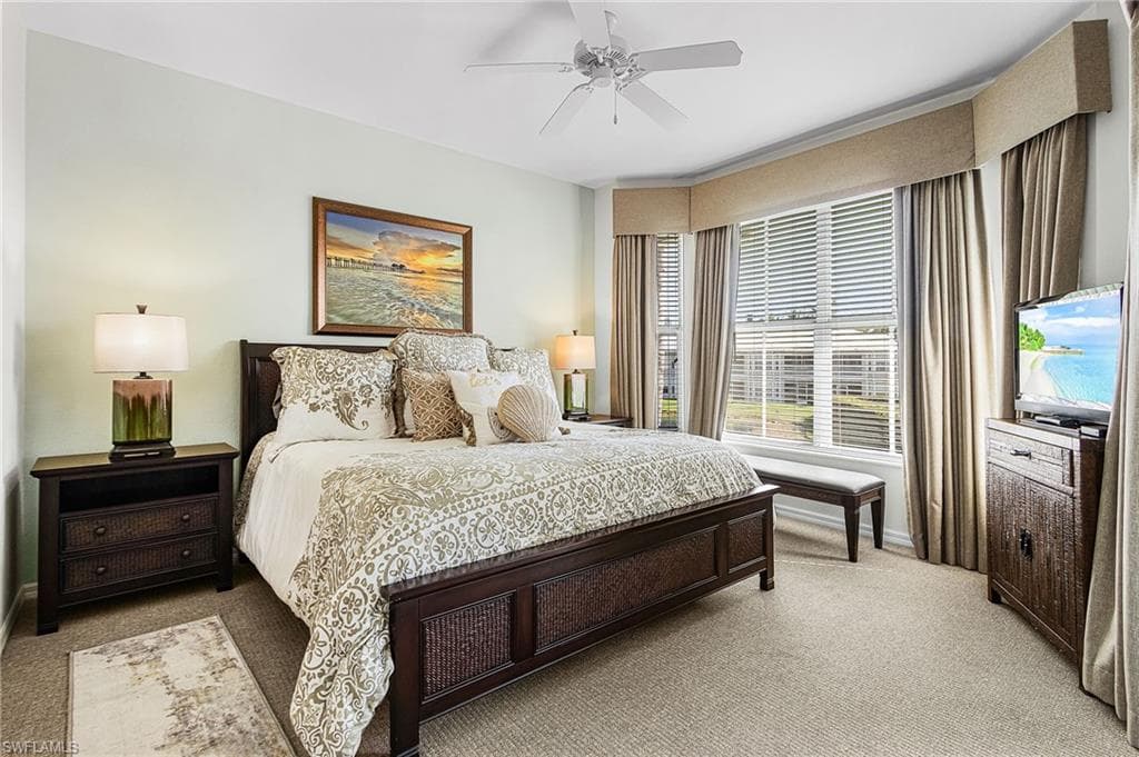 Carpeted bedroom with a ceiling fan and baseboards