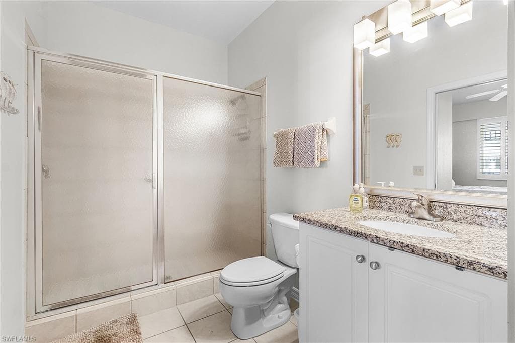 Bathroom with a stall shower, vanity, and light tile patterned floors