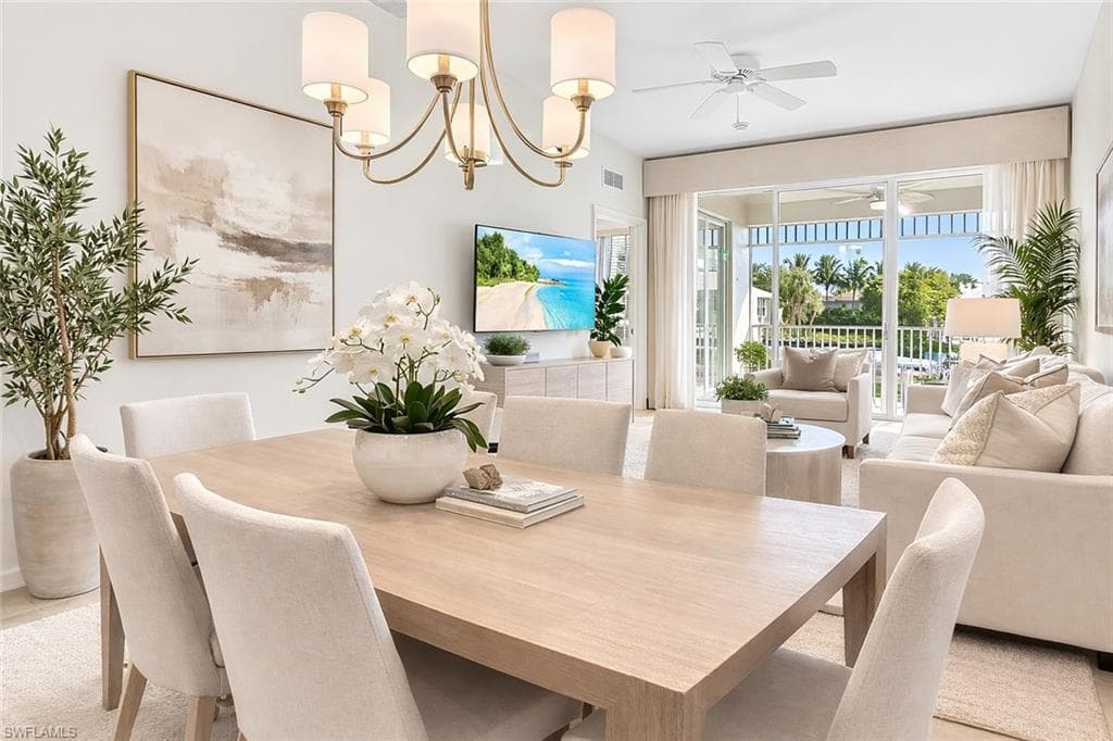 Virtual staged dining area with a chandelier and ceiling fan
