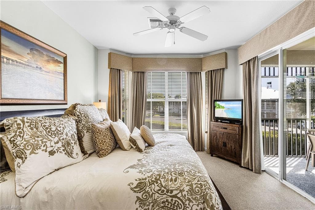 Bedroom featuring light colored carpet, access to exterior, and a ceiling fan