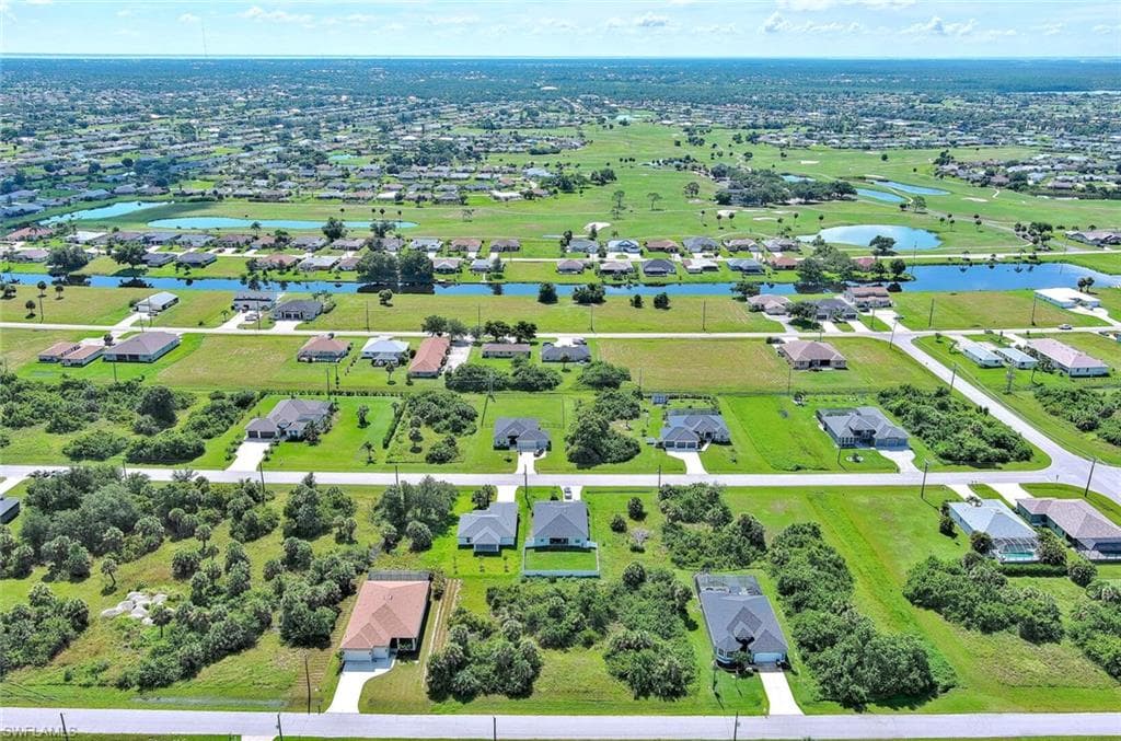Aerial perspective of suburban area featuring a nearby body of water