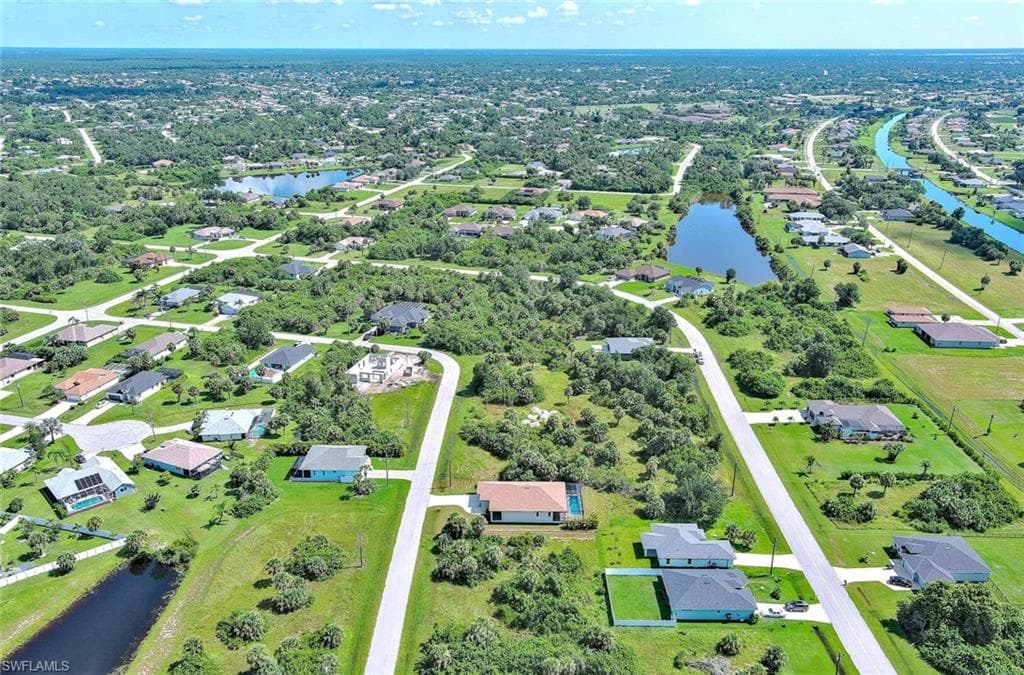Aerial view of property's location with a nearby body of water and nearby suburban area