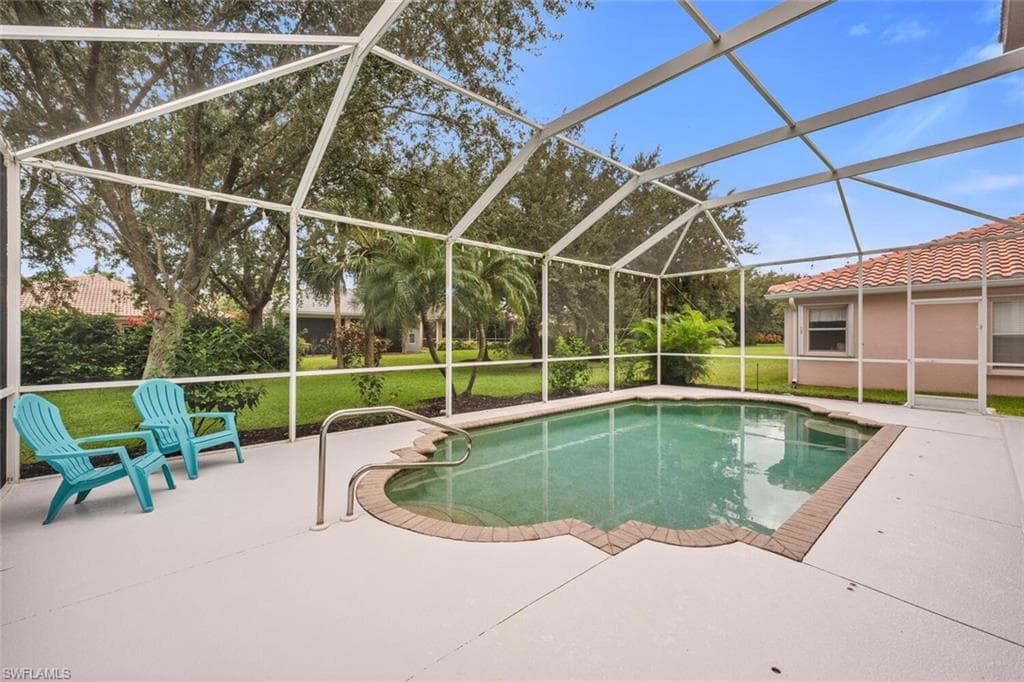 Swimming pool with a yard, glass enclosure, a sunroom, and a patio