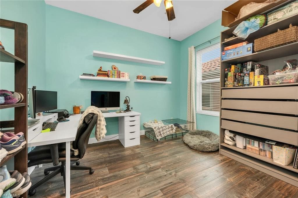 Home office featuring dark wood-style flooring and a ceiling fan