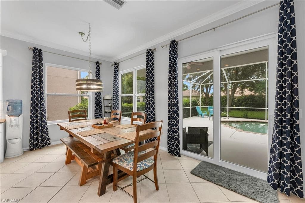 Dining area featuring ornamental molding and light tile patterned floors