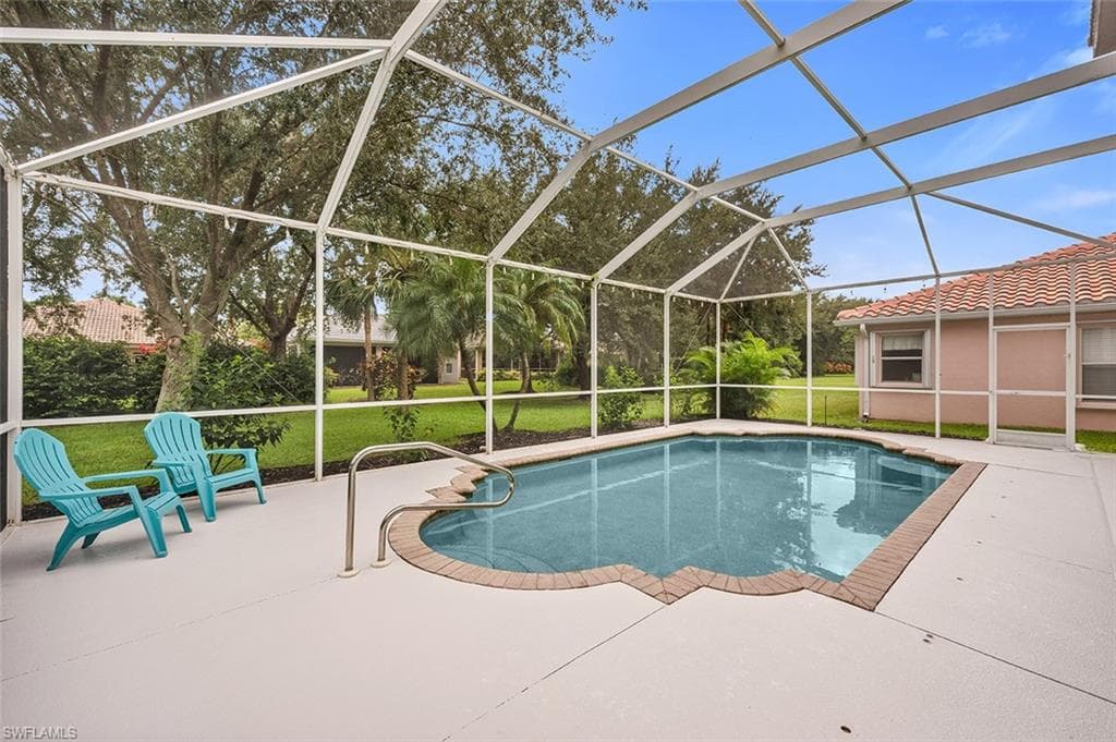 Outdoor pool featuring a lawn, a lanai, a patio, and a sunroom