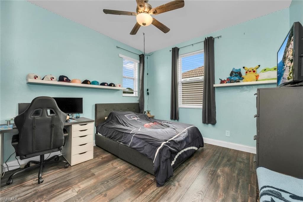 Bedroom featuring a desk, dark wood-style floors, and ceiling fan