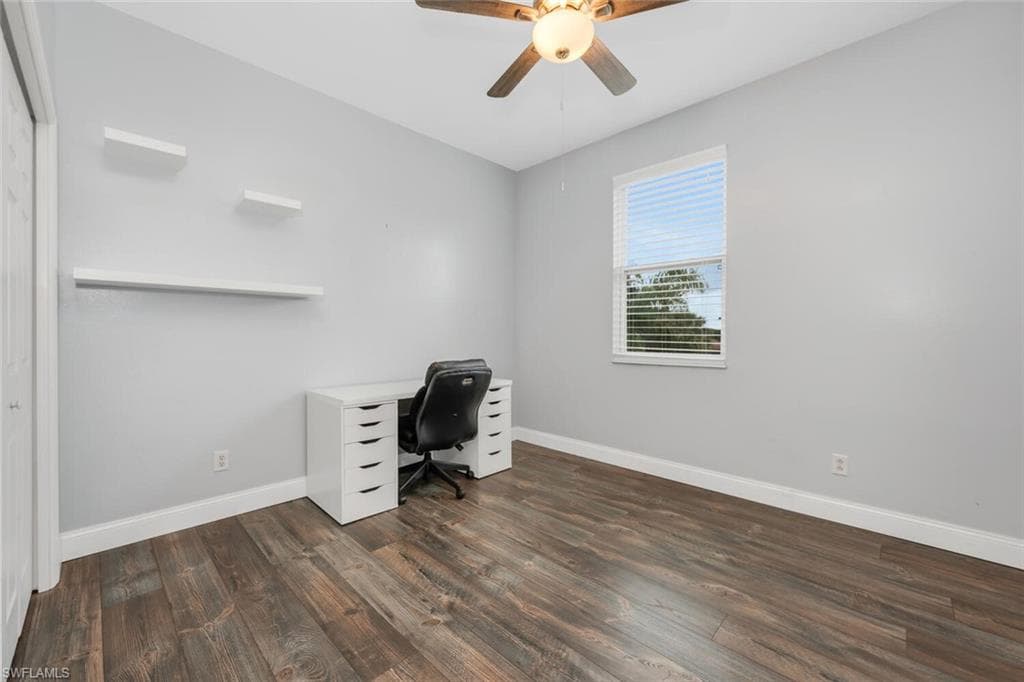 Unfurnished office featuring dark wood-style flooring and ceiling fan