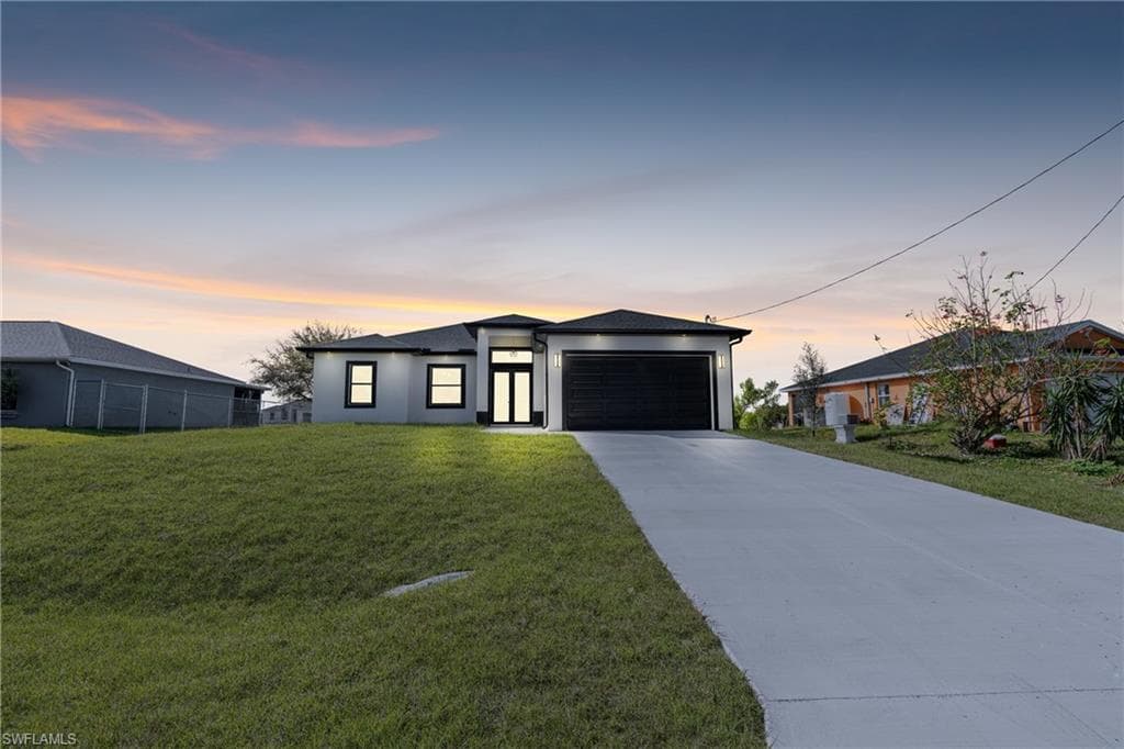 View of front of house featuring concrete driveway, a garage, and stucco siding