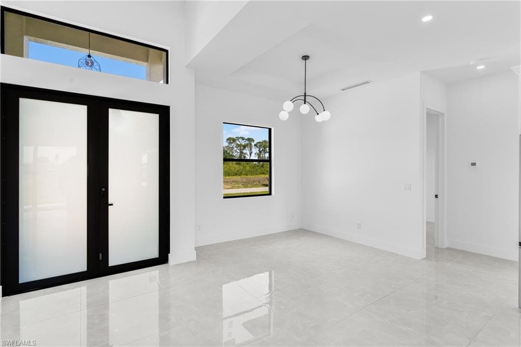 Spare room with a chandelier, recessed lighting, and light tile patterned floors