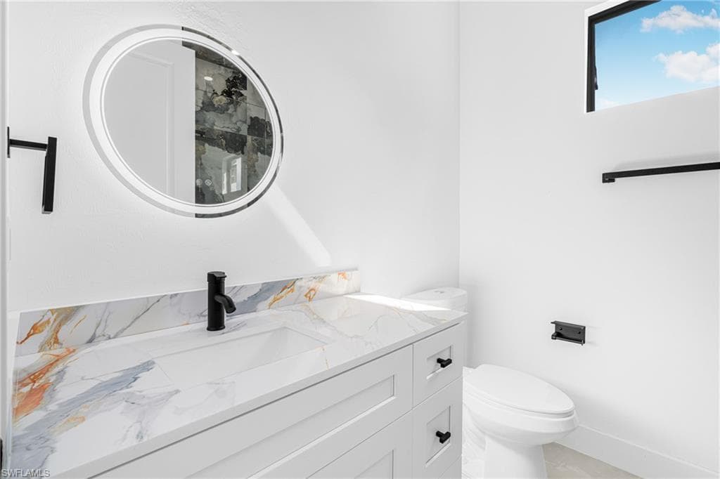Half bathroom with vanity and toilet