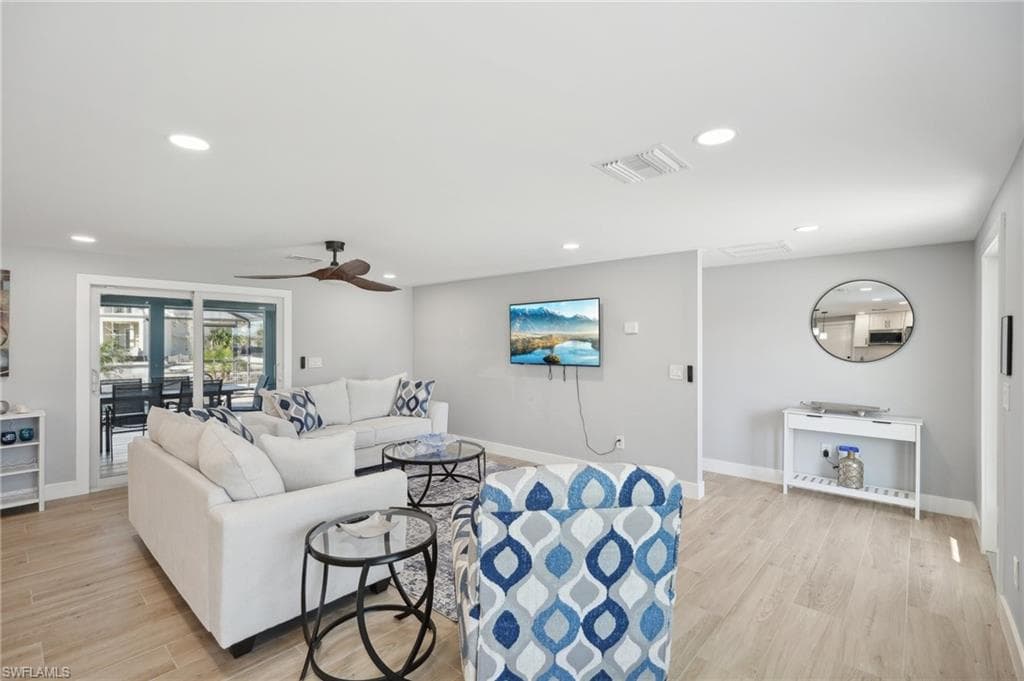 Living room with light wood-type flooring, ceiling fan, and recessed lighting