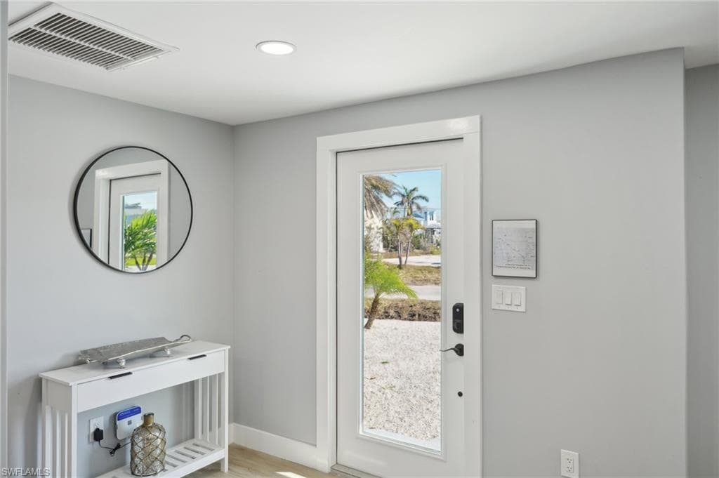 Entryway featuring healthy amount of natural light, recessed lighting, and wood finished floors