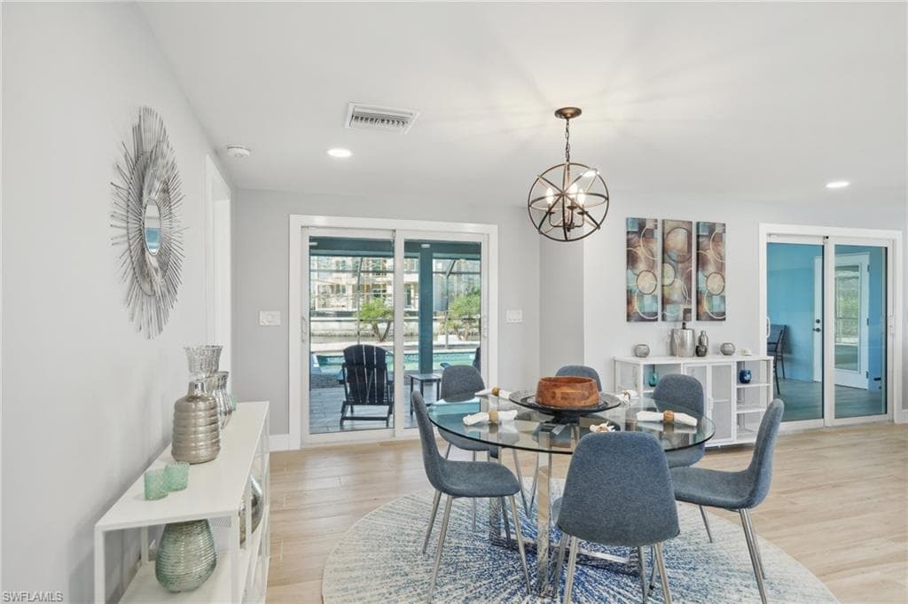 Dining area with a chandelier, light wood-style flooring, and recessed lighting