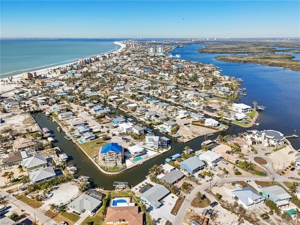 Aerial view of property's location featuring a nearby body of water and nearby suburban area