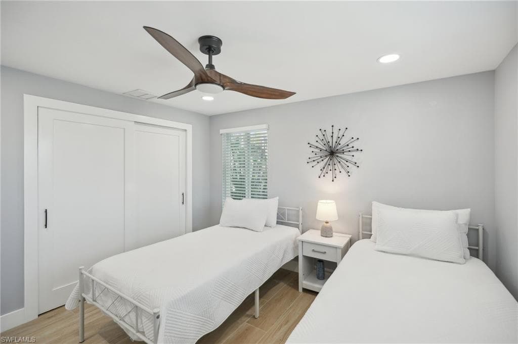 Bedroom with light wood-style floors, a closet, a ceiling fan, and recessed lighting