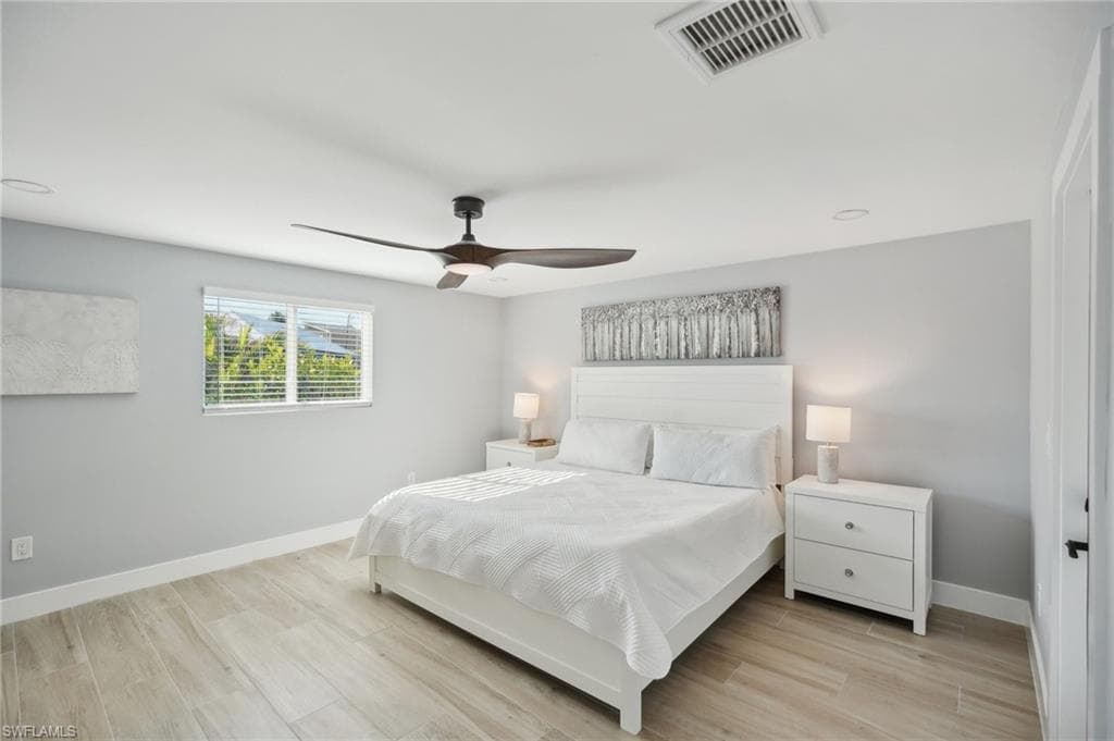 Bedroom with light wood-style floors, a ceiling fan, and recessed lighting
