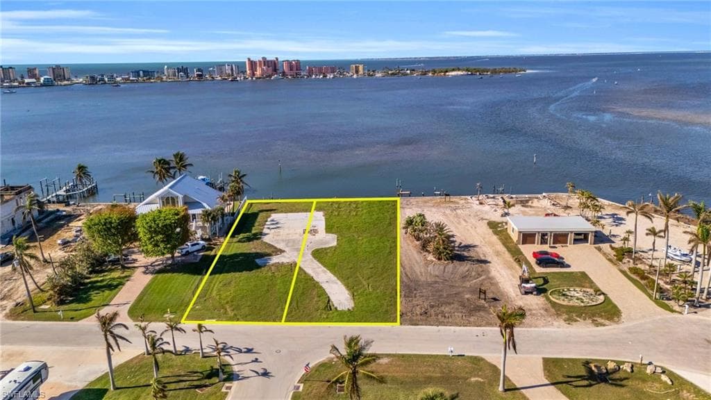 View of urban area featuring a nearby body of water and property boundaries highlighted - Virtually Edited Image