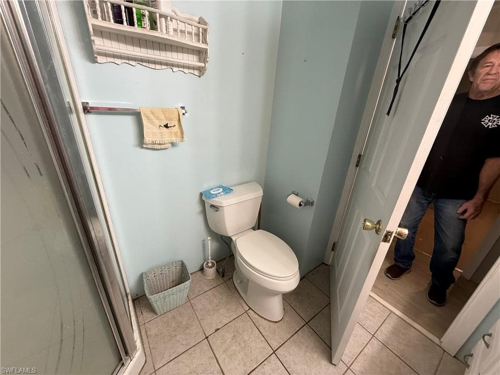 Full bathroom featuring toilet and light tile patterned floors