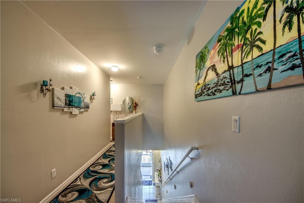 Hallway with an upstairs landing and a textured wall