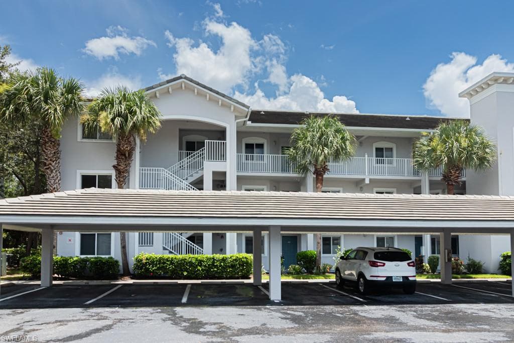 View of property featuring covered parking and stairway