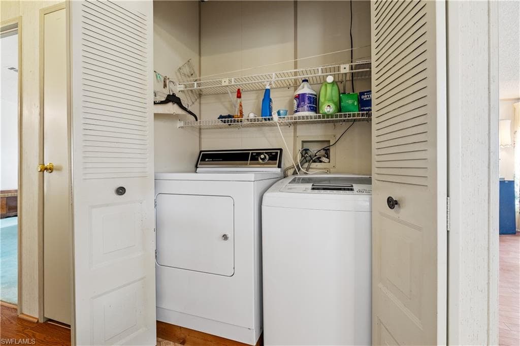Laundry room with light wood-style floors and washer and dryer