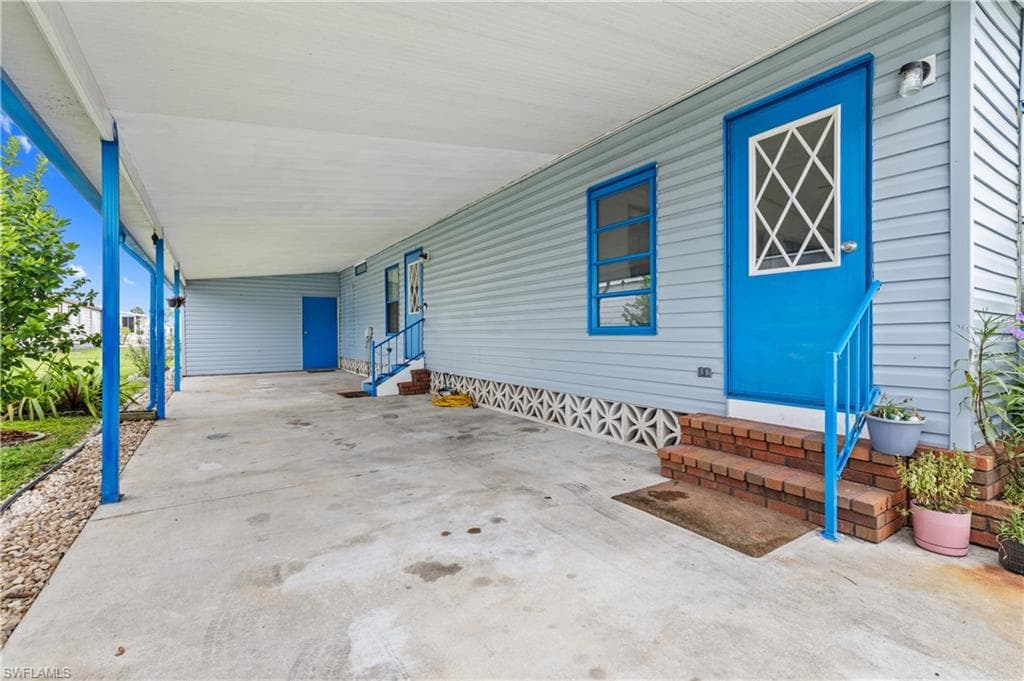 View of front facade with entry steps, a patio area, and a carport