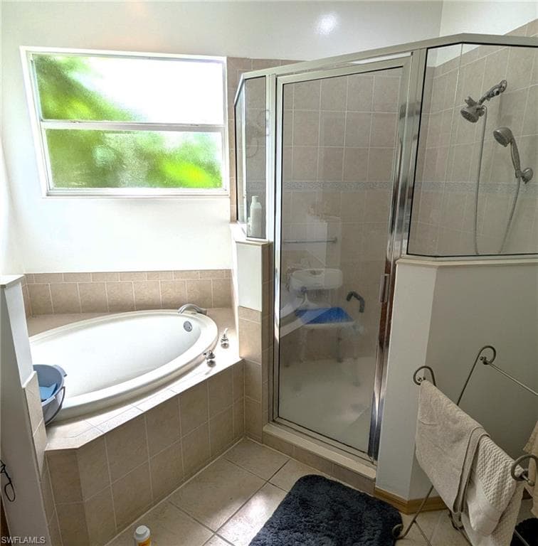Bathroom featuring a stall shower, a bath, and light tile patterned floors