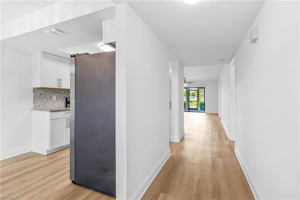 Corridor featuring light wood finished floors and baseboards