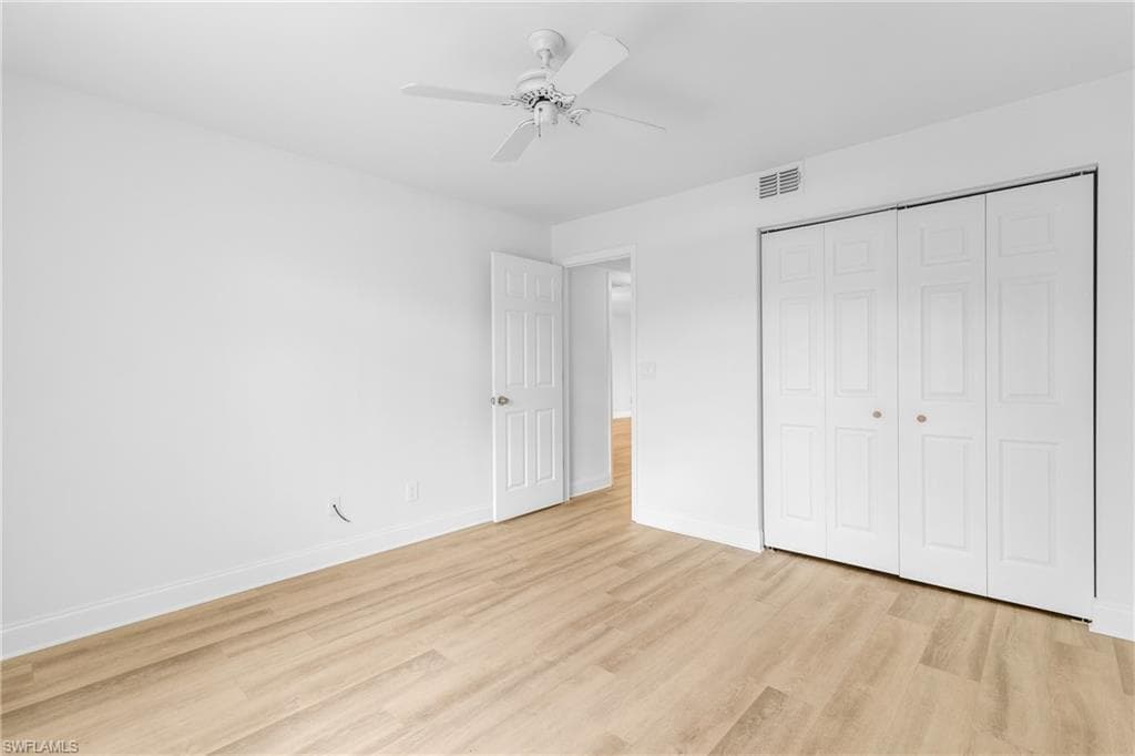 Unfurnished bedroom with light wood finished floors, ceiling fan, and a closet
