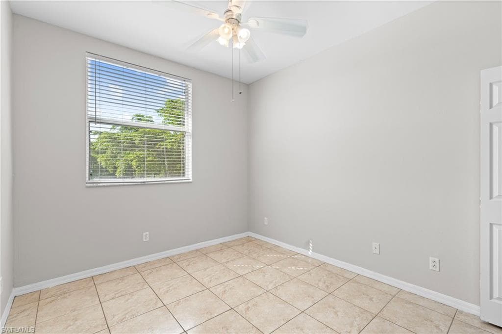 Spare room with ceiling fan and light tile patterned floors
