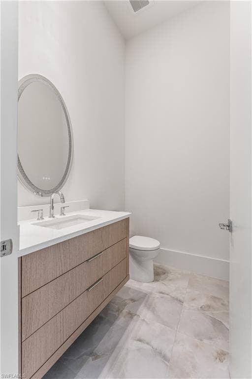 Half bath featuring vanity and toilet