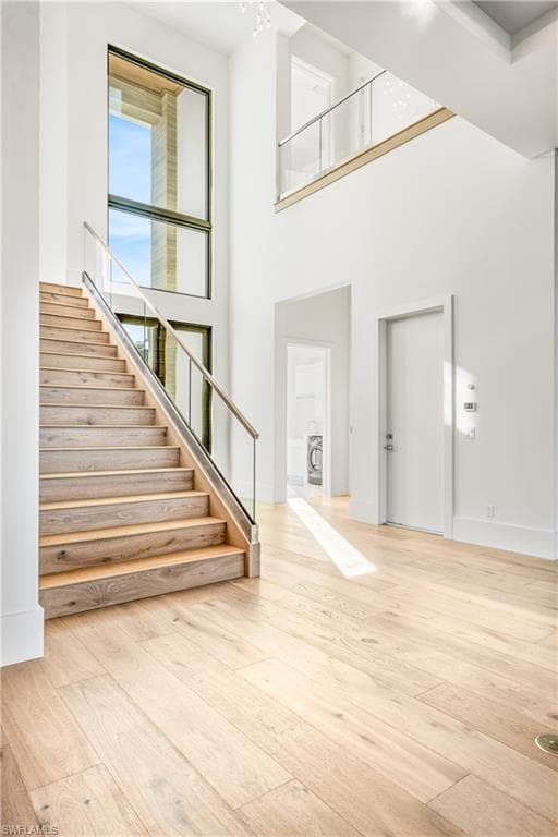 Foyer entrance with light wood-style floors and a high ceiling