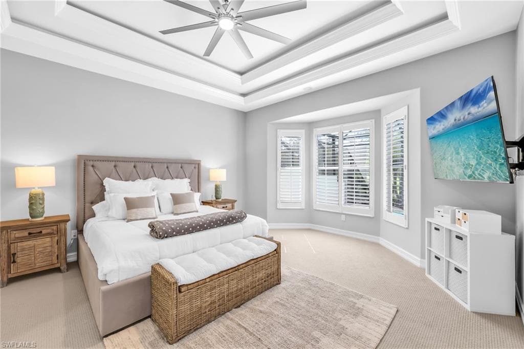 Bright and airy Primary bedroom, freshly painted, new carpet, arched walkways, a tray ceiling, and a ceiling fan