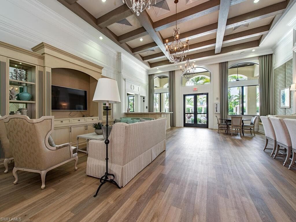 Living room featuring an inviting chandelier, french doors, wood-type flooring, coffered ceiling, and beam ceiling