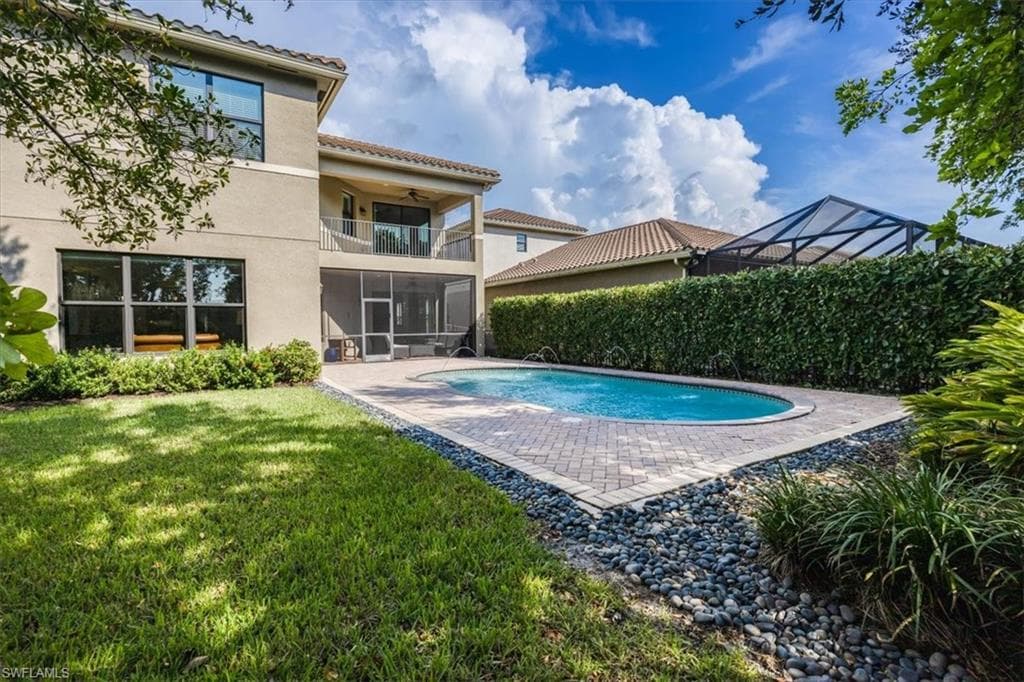 View of pool featuring a patio and a lawn