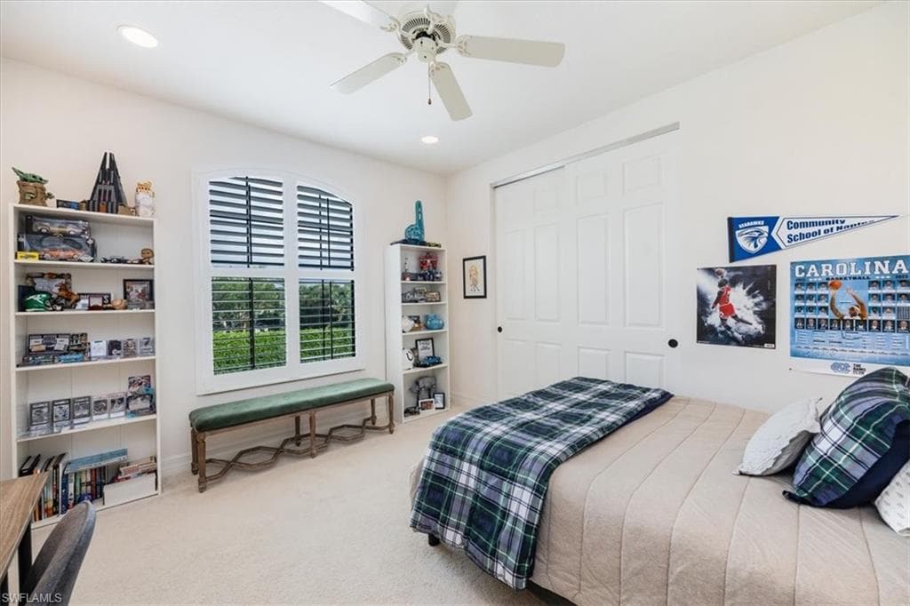 Carpeted bedroom featuring a closet and ceiling fan